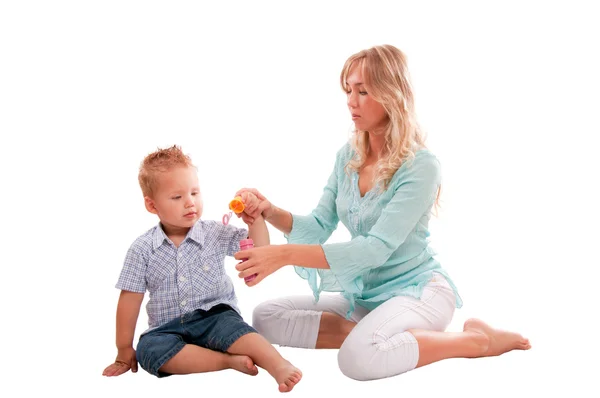 Portrait of happy mother with joyful son playing with soap bubbl — Stock Photo, Image