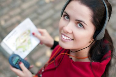 Young woman with headphones, listening to audio guide clipart