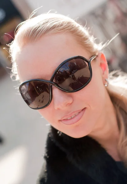 Genç bir kadın büyük modern güneş gözlüğü takıyor. — Stok fotoğraf