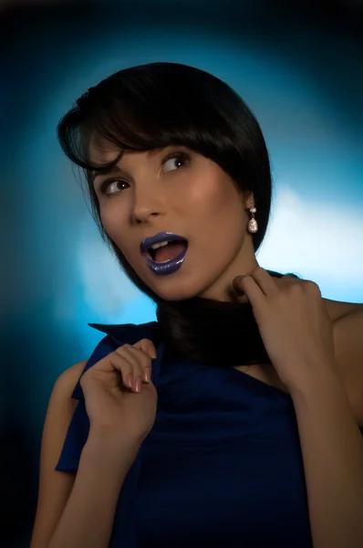 Porträtt av vacker ung kvinna på blå bakgrund — Stockfoto