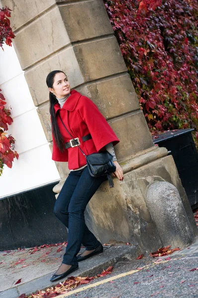 路上で赤いコートの若い女性 — ストック写真