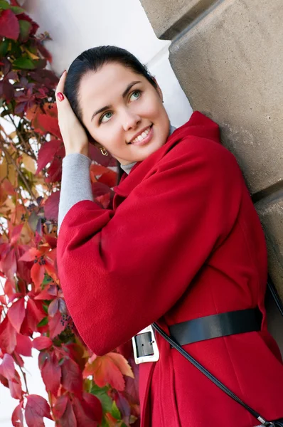 Young women in red coat on the street — Stock Photo, Image