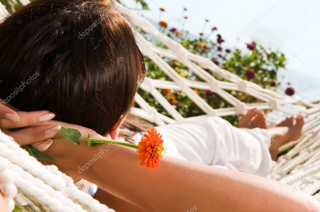 Young woman in hammock, focus on the flower