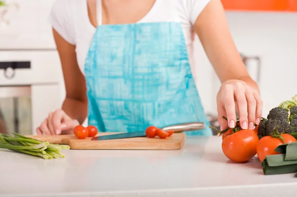 Femme coupant des légumes dans une cuisine — Photo