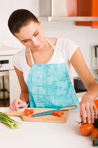 Donna che taglia verdure in una cucina — Foto Stock