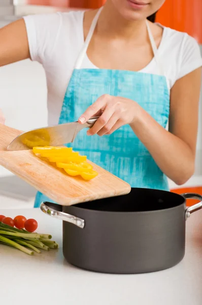 Mujer sonriente cortando verduras en el interior de la cocina moderna —  Fotos de Stock