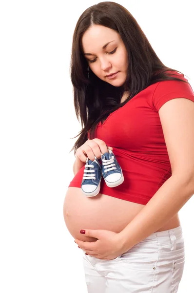 Uma mulher grávida segurando sapatos de bebê — Fotografia de Stock