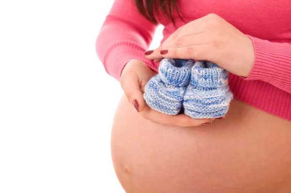 A terhes nő, kezében a baba cipő — Stock Fotó