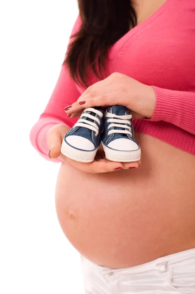 一个怀孕的女人抱着婴儿鞋 — 图库照片