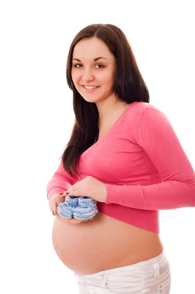 Una mujer embarazada sosteniendo zapatos de bebé —  Fotos de Stock
