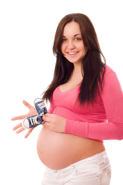 Una mujer embarazada sosteniendo zapatos de bebé — Foto de Stock