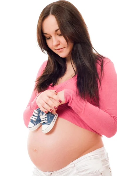 赤ちゃんの靴を保持している妊娠中の女性 — ストック写真