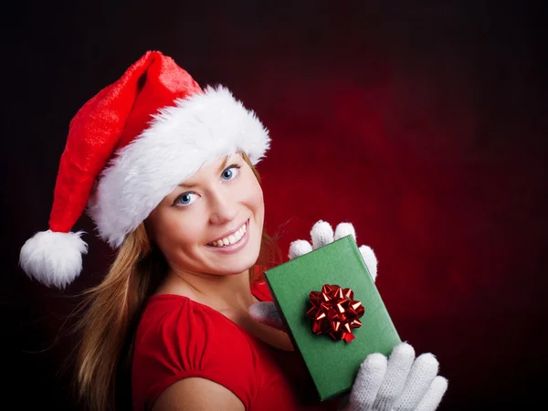 Молодая рождественская женщина держит подарок над темнотой — стоковое фото