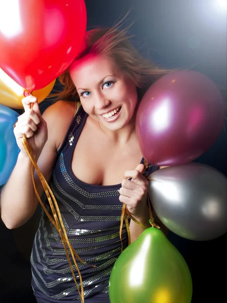 Улыбающаяся женщина на вечеринке с воздушными шарами — стоковое фото
