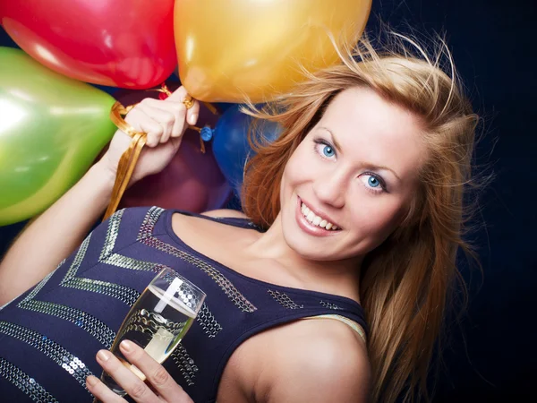 Усміхнена жінка тримає новорічне шампанське і повітряні кулі — стокове фото