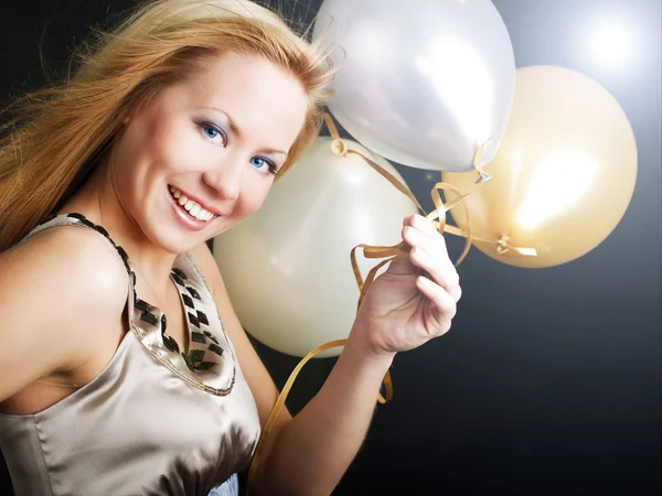 Mujer sonriente en fiesta sosteniendo globos —  Fotos de Stock