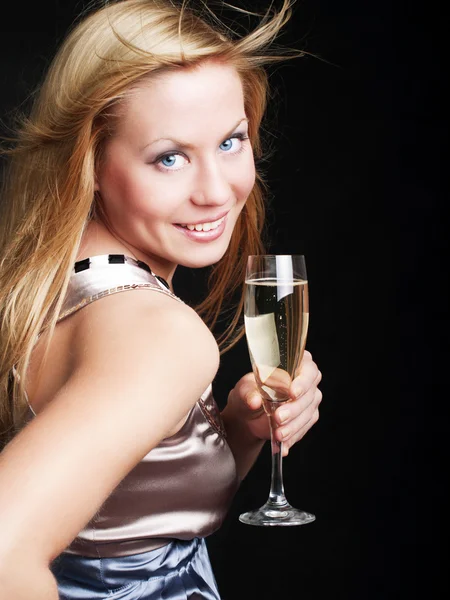 Smiling young woman with sylvester champagne over dark — Stock Photo, Image
