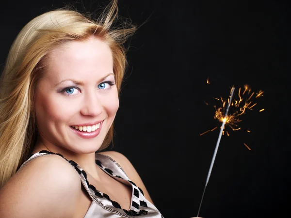 Genç kadın holding yeni yıl maytap karanlık üzerinde gülümseyen — Stok fotoğraf