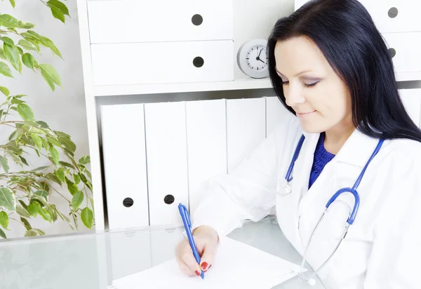 Medico donna scrittura prescrizione in ufficio — Foto Stock