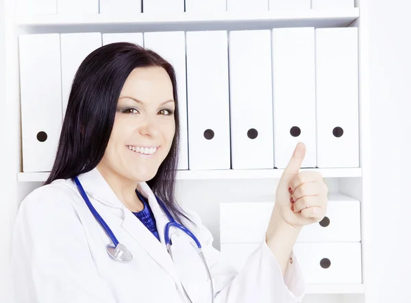 Улыбающаяся женщина-врач со стетоскопом в кабинете — стоковое фото