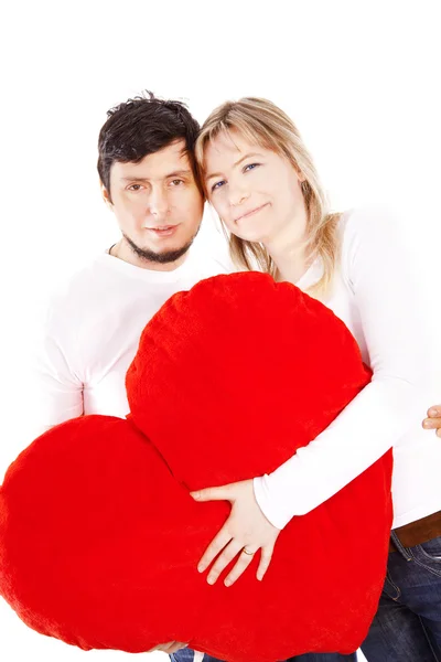 Feliz casal segurando vermelho coração travesseiro sobre branco — Fotografia de Stock