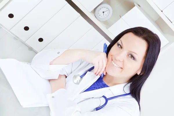 手術室でノートを作る医者女性の笑みを浮かべてください — ストック写真