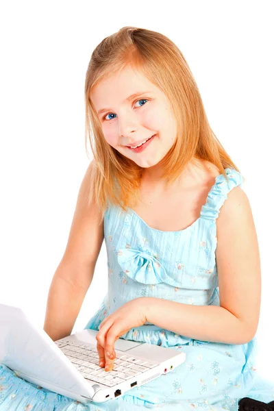 Улыбающаяся маленькая девочка, работающая с компьютером — стоковое фото