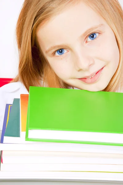 Usměvavá malá holčička s knihami na stole — Stock fotografie