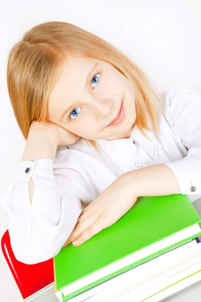 Sorrindo menina pequena com livros na mesa — Fotografia de Stock