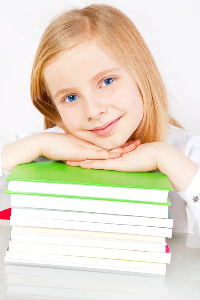 Χαμογελώντας μικρό κορίτσι με τα βιβλία στο τραπέζι — Φωτογραφία Αρχείου