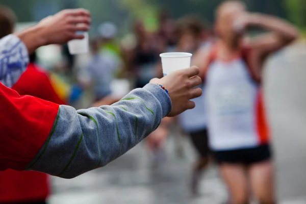 Runner take a water in a marathon race — Stock Photo, Image
