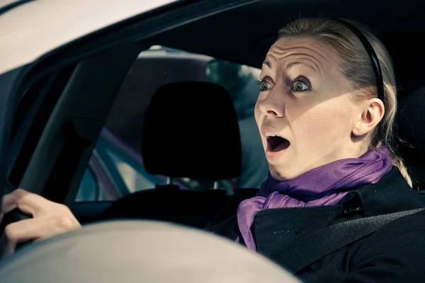 Young woman screams while driving a car — Stock Photo, Image