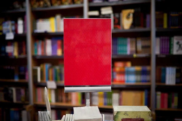 Espace publicitaire rouge en librairie - de nombreux livres en arrière-plan — Photo