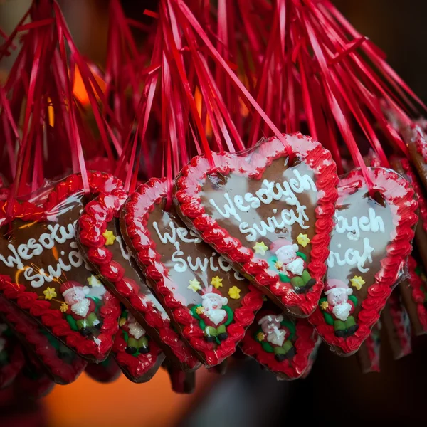 stock image Baked gingerbread hearts hanging on red ribbon outdoors