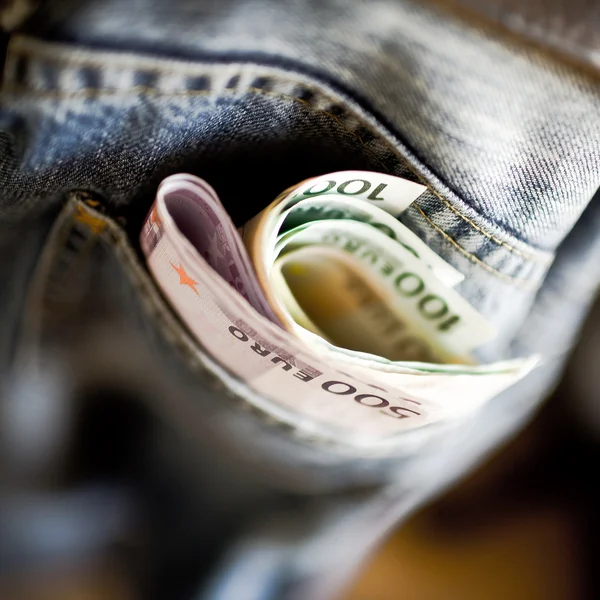Dinero de bolsillo: billetes en euros en un bolsillo de un pantalón vaquero azul — Foto de Stock