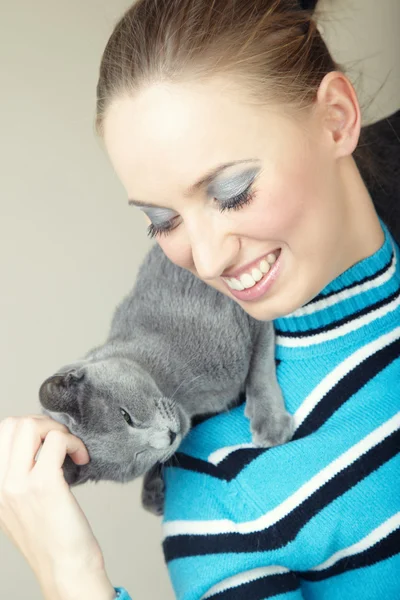 女性は彼女の猫を屋内で贅沢な笑みを浮かべてください 自然光と色 — ストック写真