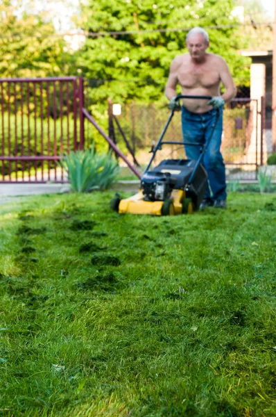 Homme coupant l'herbe avec la tondeuse — Photo