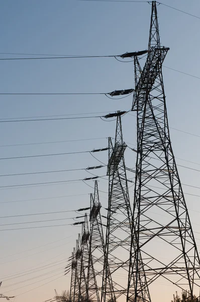 日没のパイロンと伝送電力線 — ストック写真