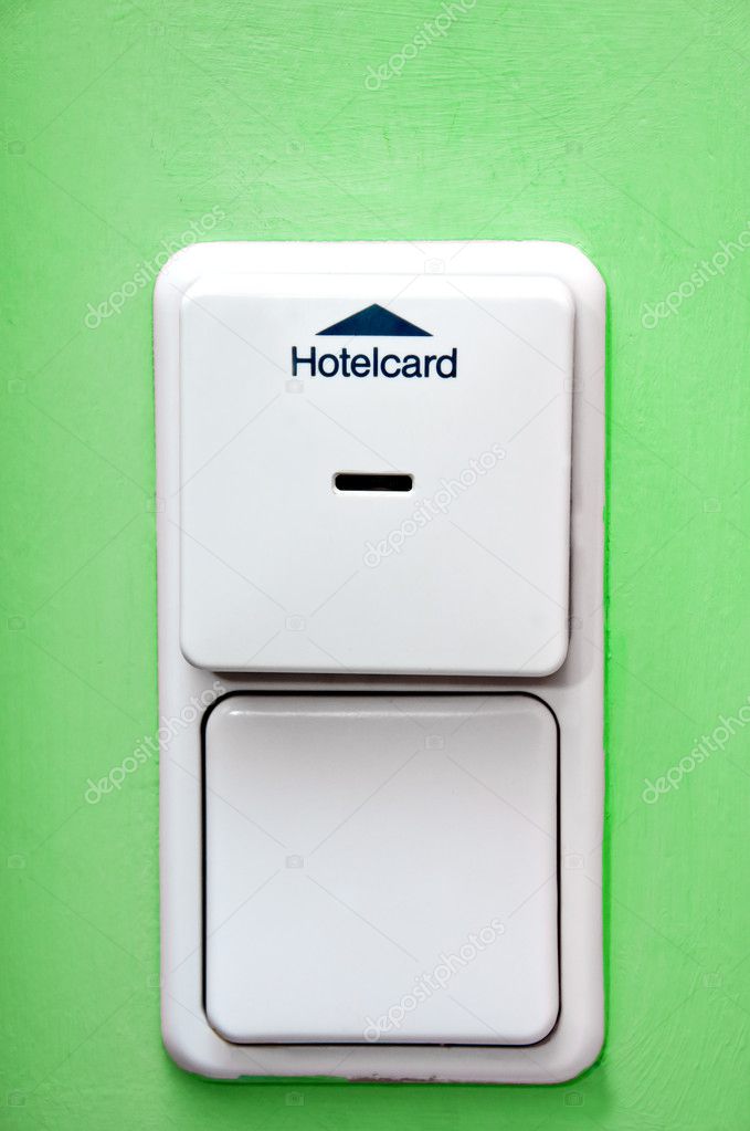 Hotel card holder on green wall and light switch