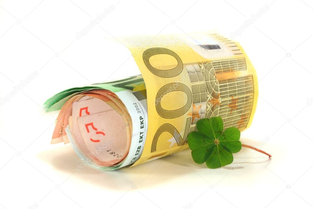 Euro notes with four-leaf clover on white background