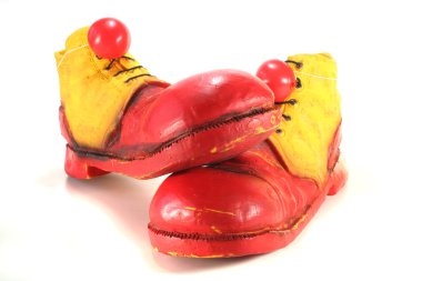 Red and yellow clown shoes with red clown noses on white background clipart