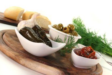 Olives, stuffed vine leaves and dried tomatoes clipart