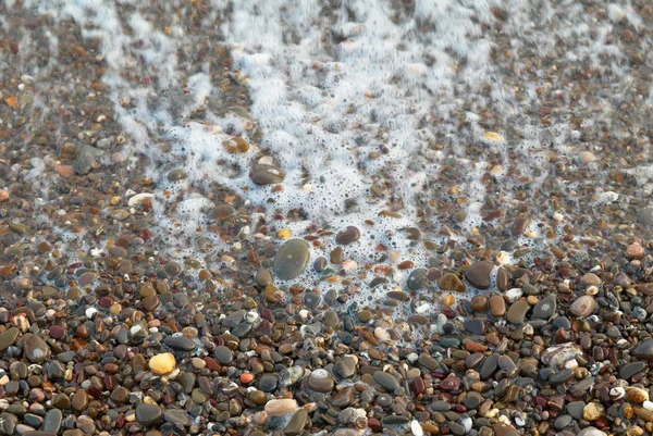 Wave, pěny a tvarovaných kamenů. — Stock fotografie