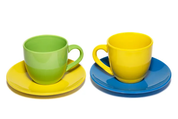Colored teacups and saucers isolated on white. — Stock Photo, Image