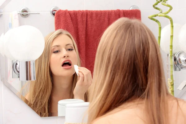 Mujer joven limpiando su cara — Foto de Stock