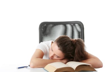 Masanın üzerinde kitap ile uyuyan genç beyaz öğrenci kadın