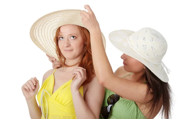 在夏天的衣服和帽子上白色背景中的两个女朋友 — 图库照片