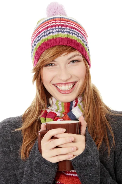 Женщина в зимней кепке пьет что-то горячее — стоковое фото