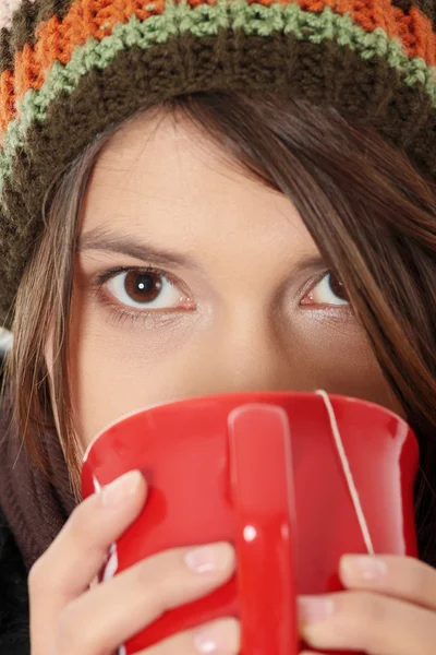 何かを飲んで防寒帽を持つ若い女性ホット 白の由来 — ストック写真