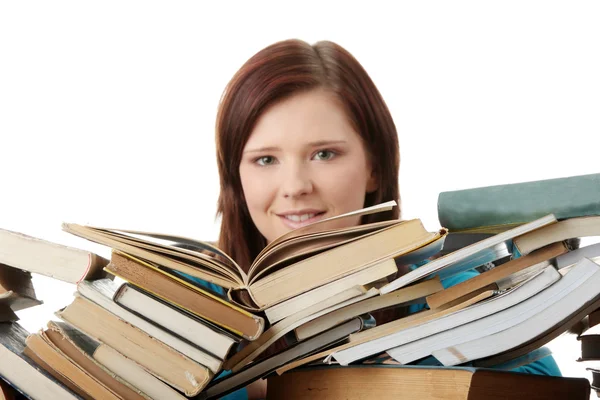 Jonge vrouw achter boeken — Stockfoto